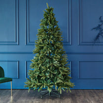Green artificial Christmas tree against a blue paneled wall