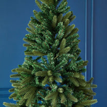 Green artificial Christmas tree against a blue door