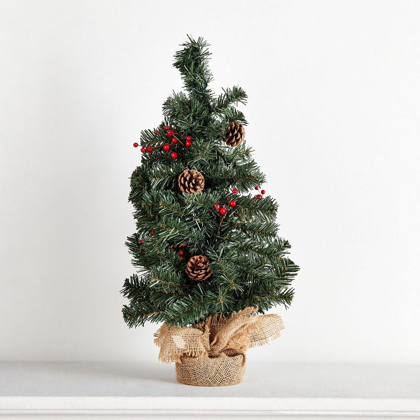 Small decorated Christmas tree with pinecones and red berries on a white background