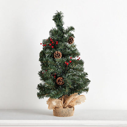 Small decorated Christmas tree with pinecones and red berries on a white background