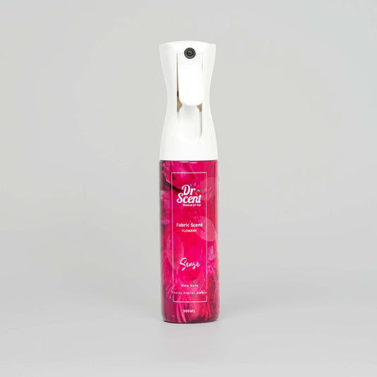 Pink spray bottle with white top on a gray background