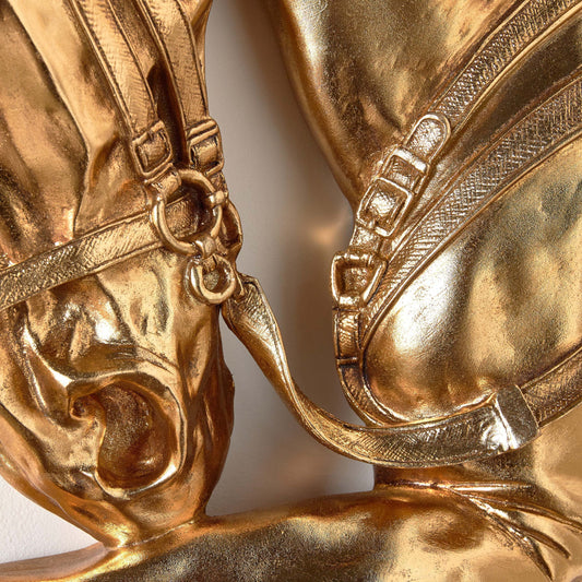 Close-up of a gold decorative item resembling a horse's head and bridle.