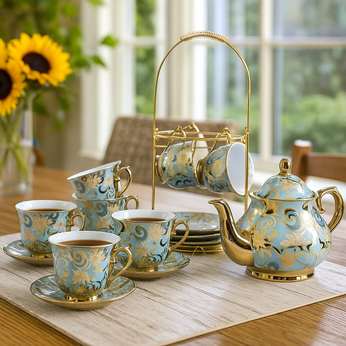 Ceramic tea set with teapot, cups, and saucers on a table with a window view.