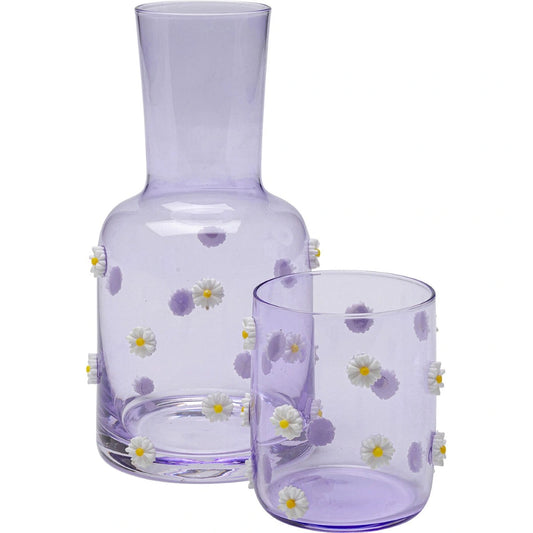 Purple glass carafe and tumbler set with floral designs on a white background