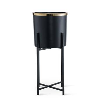 Black trash bin with gold top on a white background