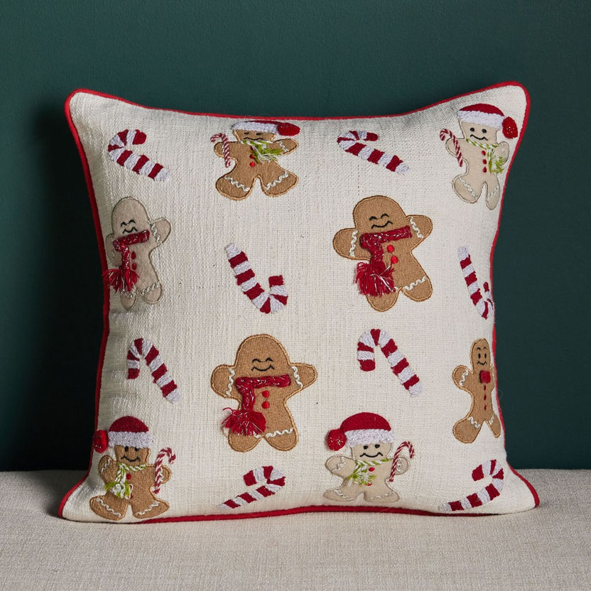 Decorative pillow with gingerbread men and candy cane pattern on a dark background