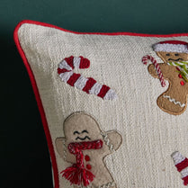 Decorative pillow with gingerbread men and candy canes on a dark background