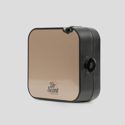 A square-shaped fragrance diffuser with a black front and a logo that reads 'DR SCENT' on the front. It has a black lid and a visible power button.