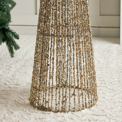 Gold sequin tree skirt on a white surface with a blurred background