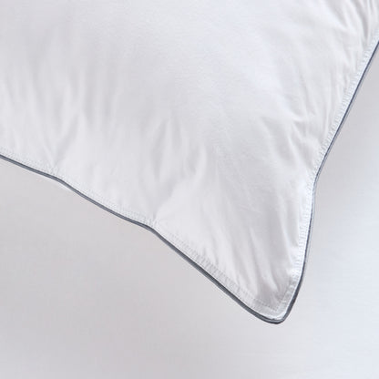 Close-up of a white comforter with a dark trim on a light gray background