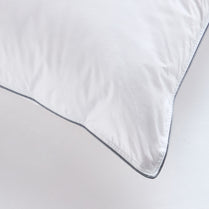 Close-up of a white comforter with a dark trim on a light gray background