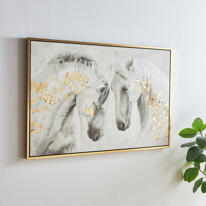 Framed artwork of two horses with gold accents on a white wall.