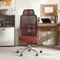 Red office chair in a home office setting with a desk and decor.