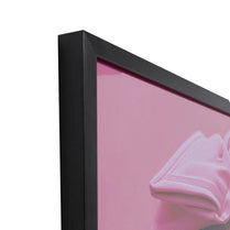 Close-up of a black frame with a pink background and a pink garment partially visible.