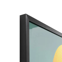 Close-up of a black framed artwork with a yellow abstract shape on a white background