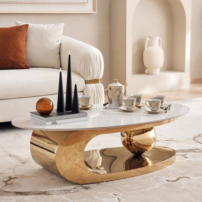 Modern living room with a gold coffee table, white sofa, and decorative items.
