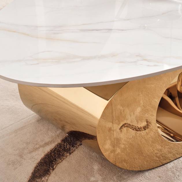 Gold coffee table with marble top on a carpeted floor