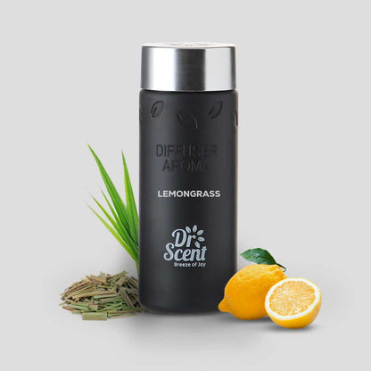 Black diffuser bottle with silver top, surrounded by lemongrass and lemons on a light gray background