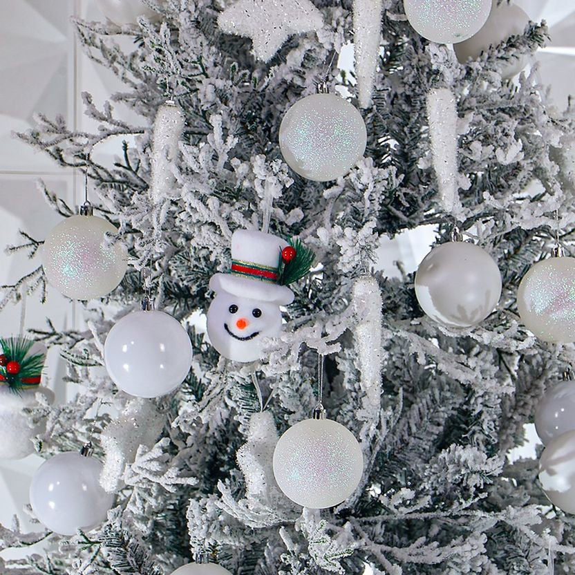 Decorative Christmas tree with white ornaments and a snowman ornament.