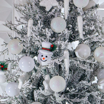 Decorative Christmas tree with white ornaments and a snowman ornament.