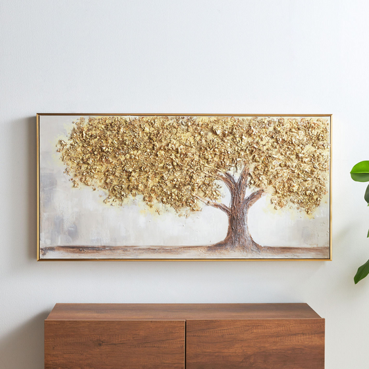 Decorative wall art of a tree with gold leaves on a white wall above a wooden cabinet.
