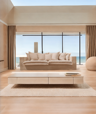 Beige sofa in a modern living room with large windows overlooking the ocean. London Collection Sofa – Minimalist Comfort for Modern Living | Vella Concept
