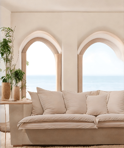 Beige sofa in a room with arched windows and a view of the ocean. London Collection Sofa – Minimalist Comfort for Modern Living | Vella Concept