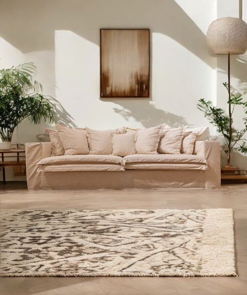 Beige sofa in a living room with a rug and plants - London Collection Sofa – Minimalist Comfort for Modern Living | Vella Concept