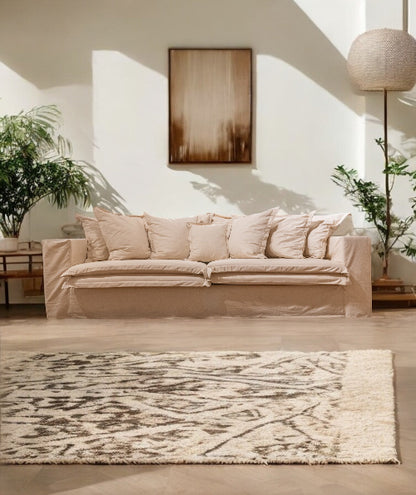 Beige sofa in a living room with a rug and plants - London Collection Sofa – Minimalist Comfort for Modern Living | Vella Concept