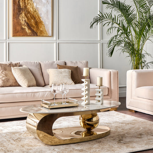 Modern living room with a gold coffee table, beige sofa, and decorative elements.