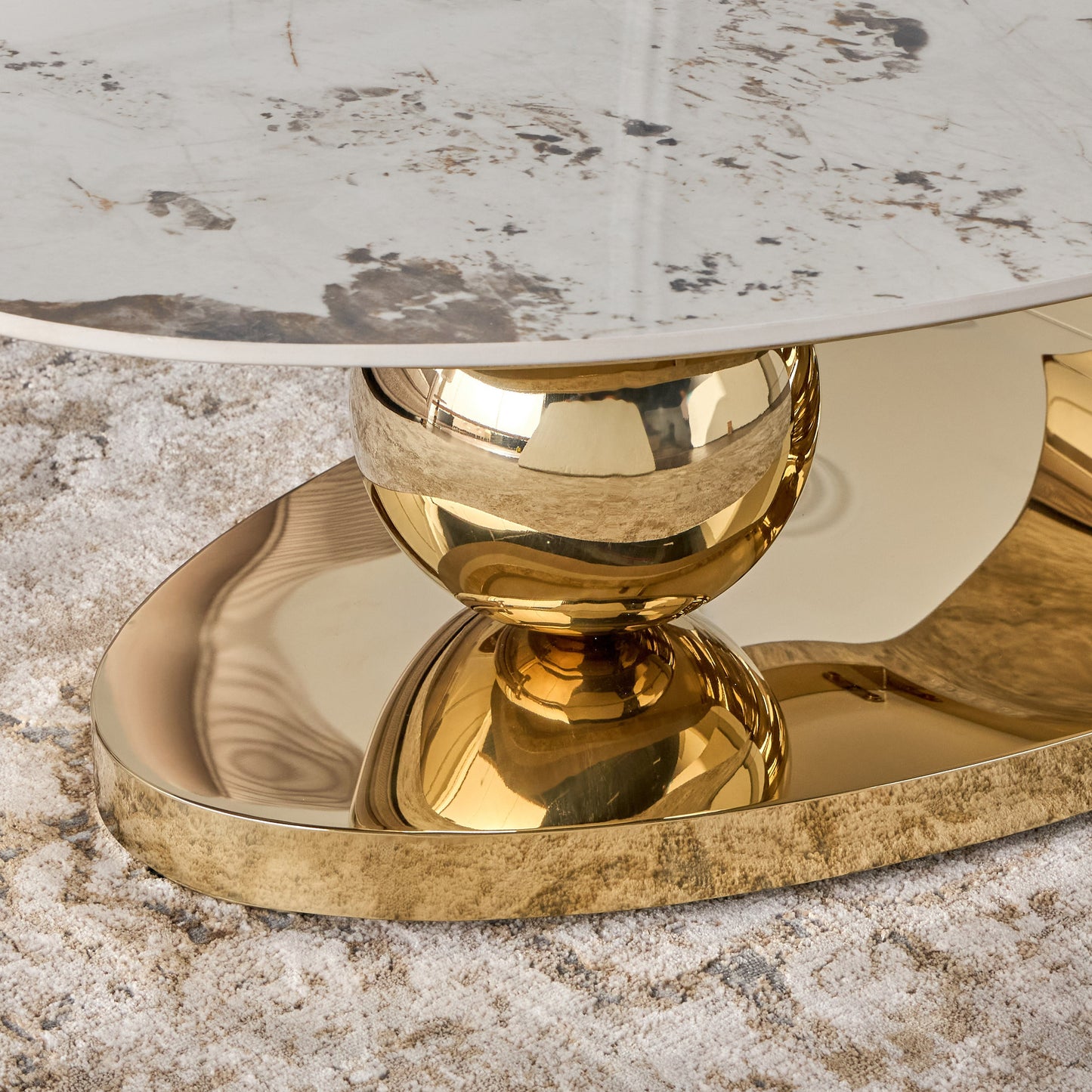 Decorative table with gold base and marble top on a textured surface