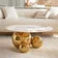 Decorative gold coffee table with a white sofa in the background