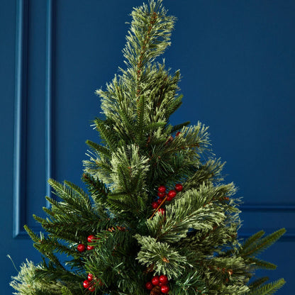 Artificial Christmas tree with red berries against a blue door background