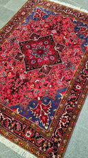 Decorative red and blue patterned rug on a light gray floor- Luxury Rug Handmade Oriental Rug | Handmade in Afghanistan – Bergamot | Luxury Living Room Décor
