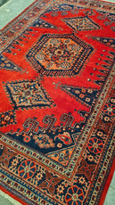 Close-up of a red patterned rug with intricate designs- Luxury Rug Handmade Persian Rug | Handmade in Iran – Bergamot | Luxury Living Room Décor