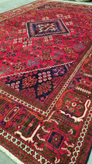 Close-up of a red patterned rug with intricate design- Luxury Rug Handmade Persian Rug | Handmade in Iran – Josheghan | Luxury Living Room Décor 