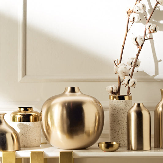 Decorative vases and a bowl on a shelf with a neutral background