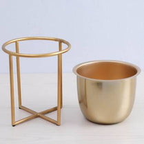 Gold metal pot and stand on a light gray background