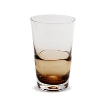 Clear glass with brown liquid on a white background