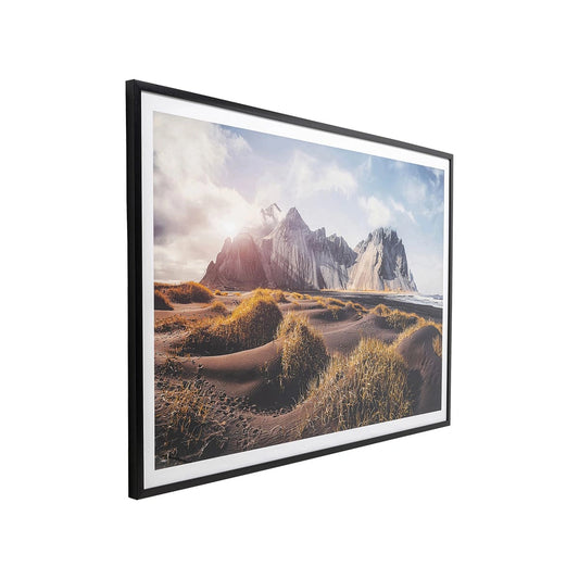 Framed artwork of a mountain landscape with grassy foreground on a white background