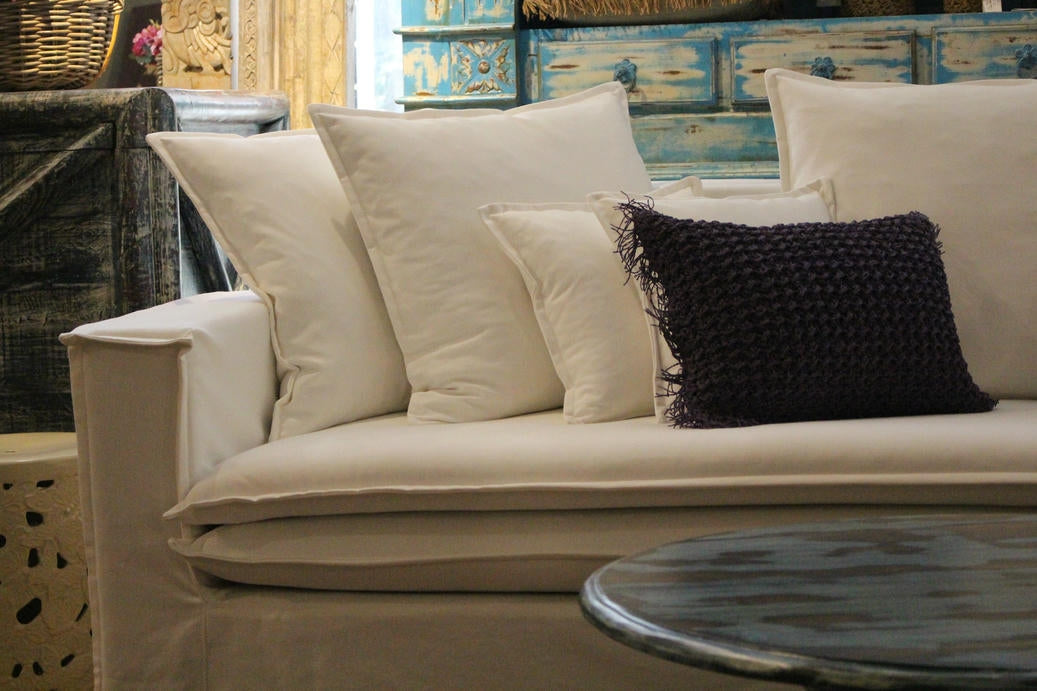 Beige sofa with decorative pillows in a room setting. New York Collection Sofa – Live in the Now | Vella Concept