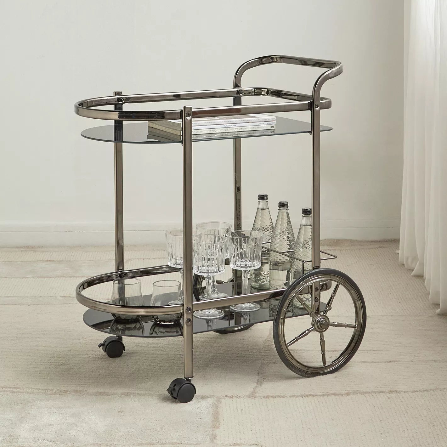 Bar cart with glass shelves and wheels in a minimalistic room.- Notica Serving Trolley - Metal & Glass 81cm