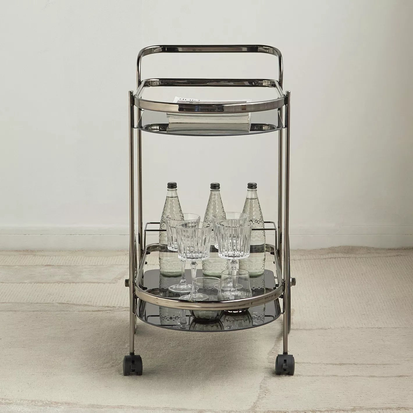 Metal bar cart with bottles and glasses on a neutral background-  Notica Serving Trolley - Metal & Glass 81cm