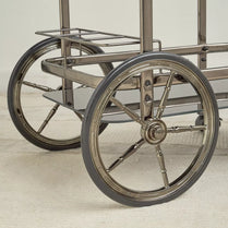 Close-up of a wheelchair with large wheels on a light background-  Notica Serving Trolley - Metal & Glass 81cm
