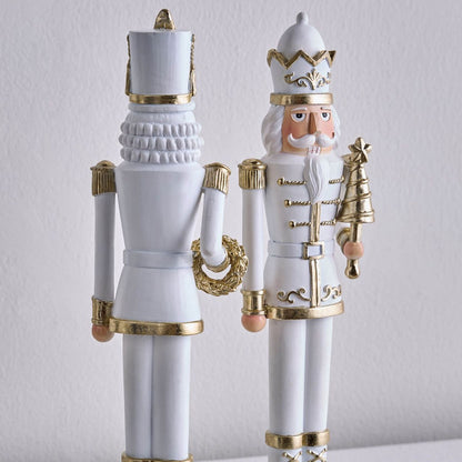 Decorative nutcrackers with white and gold attire on a light gray background