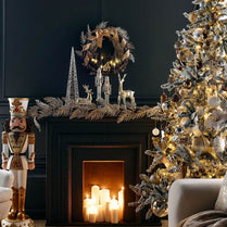 Decorated Christmas tree and fireplace with candles and ornaments in a living room.