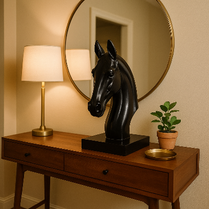Black horse head sculpture on a wooden table with a lamp, mirror, and plant in a room- Onyx Rider – Minimalist Equine Décor