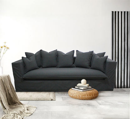 Gray sofa with decorative pillows in a modern living room setting. Paris Collection Sofa – Classic Elegance Reimagined | Vella Concept