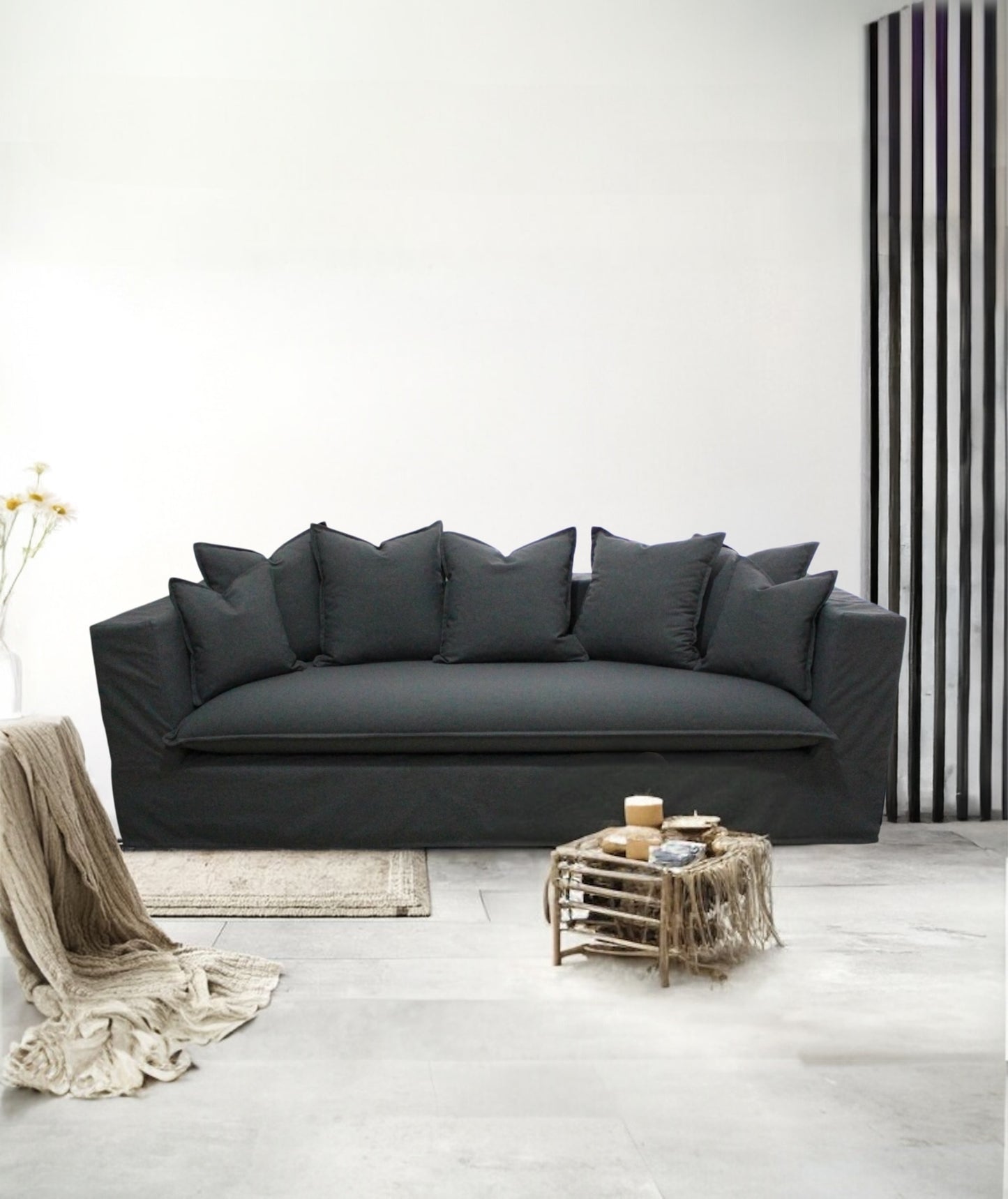 Gray sofa in a minimalistic living room with a striped wall. Paris Collection Sofa – Classic Elegance Reimagined | Vella Concept
