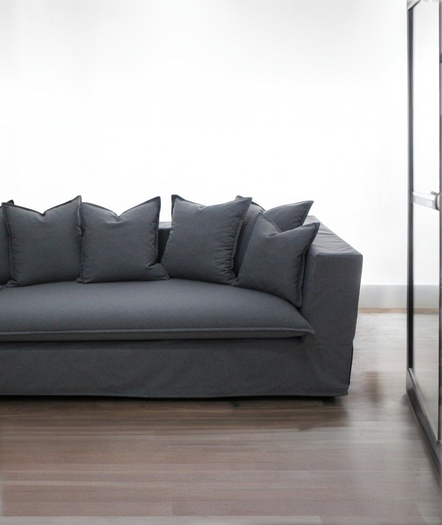 Gray sofa with decorative pillows in a minimalistic room. Paris Collection Sofa – Classic Elegance Reimagined | Vella Concept